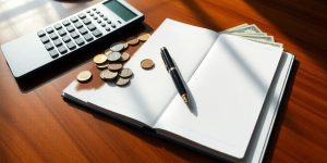 Table with financial items, pens, and calculator.